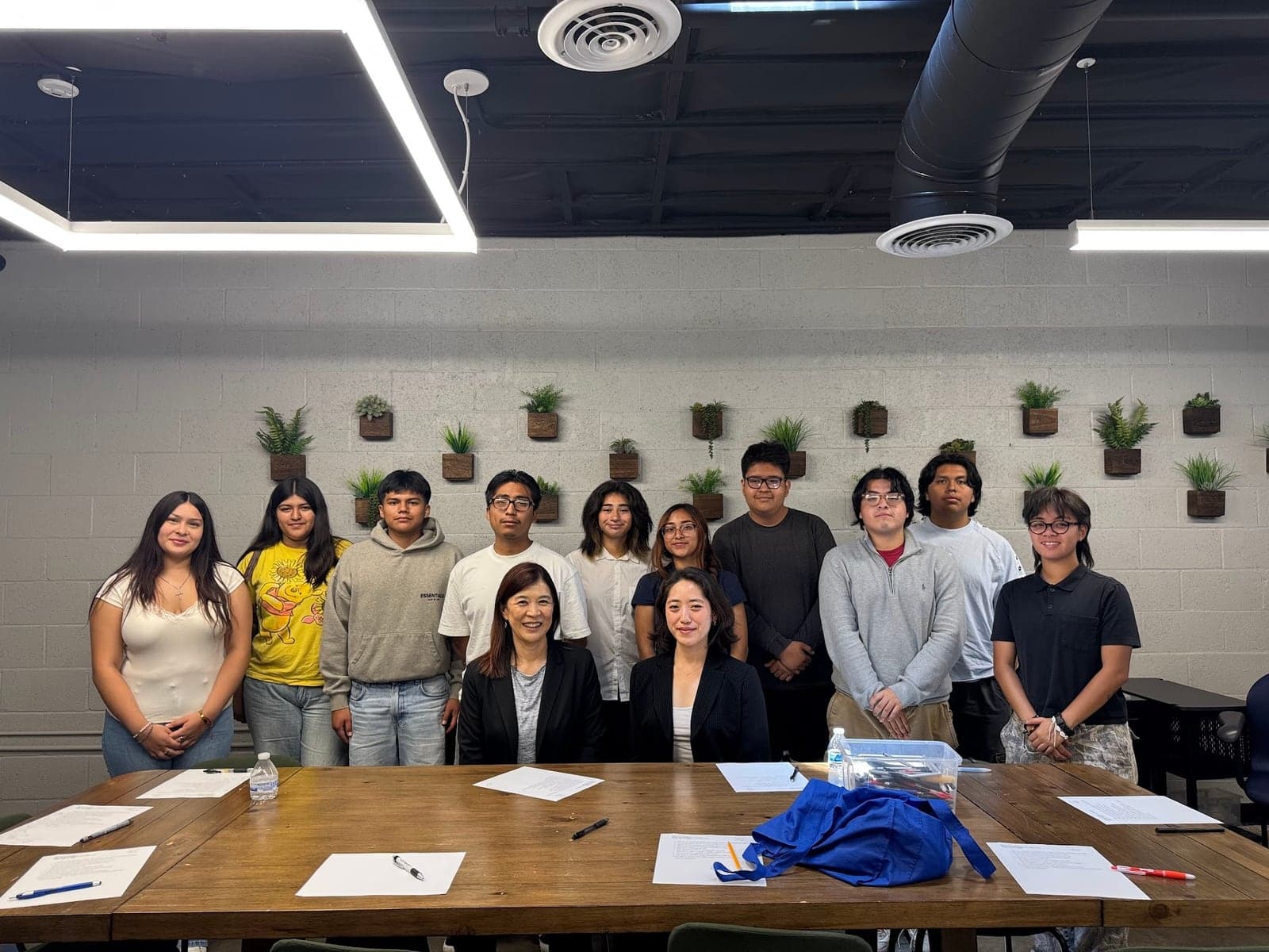 MFC youth and staff posing together around a conference table