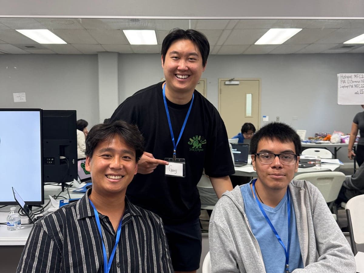 Three MFC volunteers smiling together at a workshop