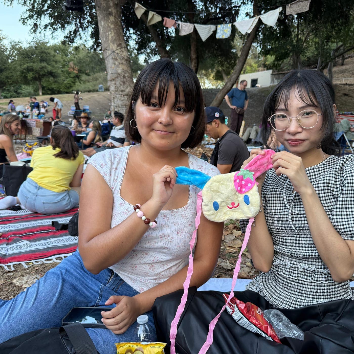 Two mentees showing off a craft at a community picnic