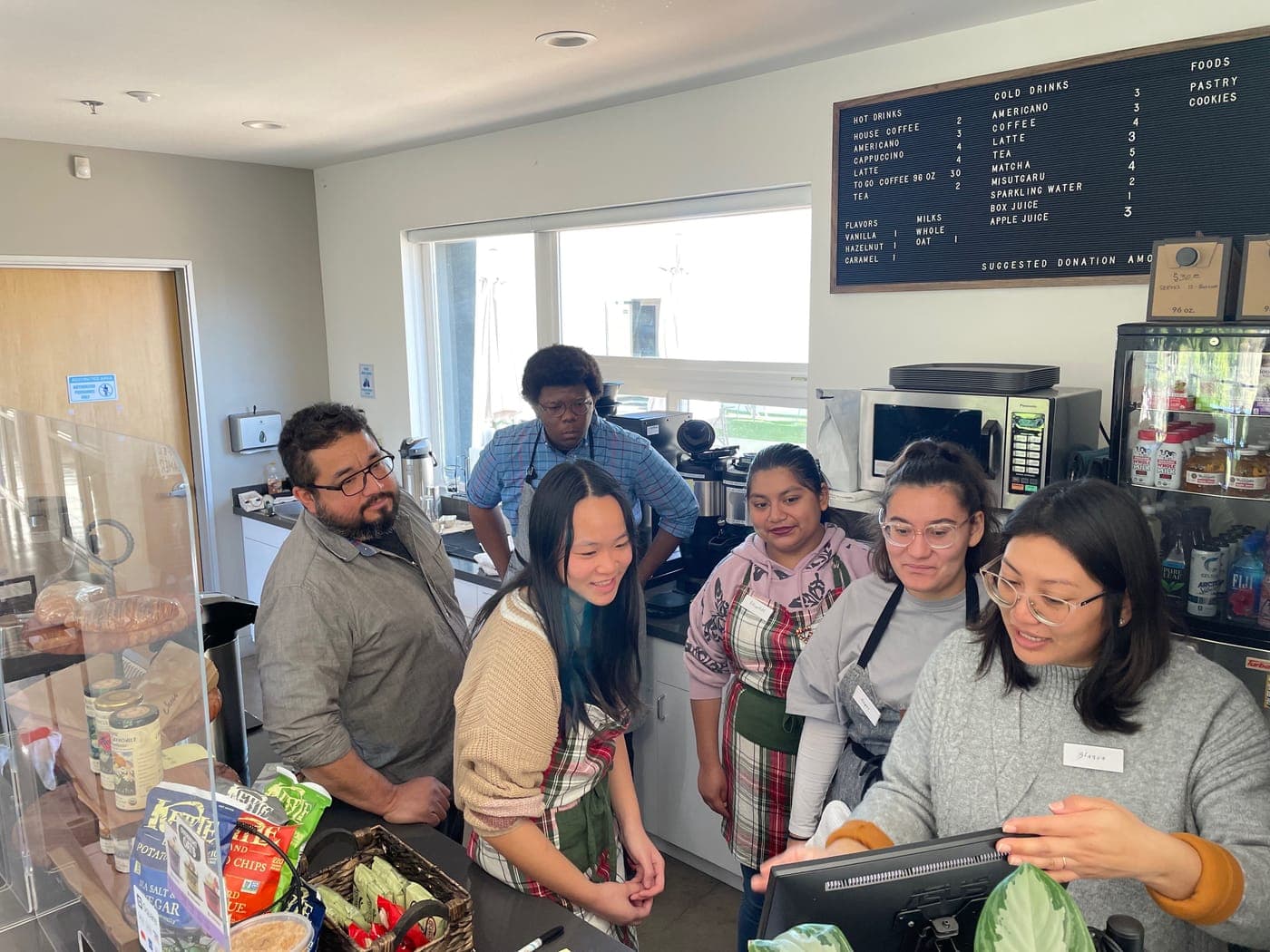 Young people learning coffee shop operations at a cafe