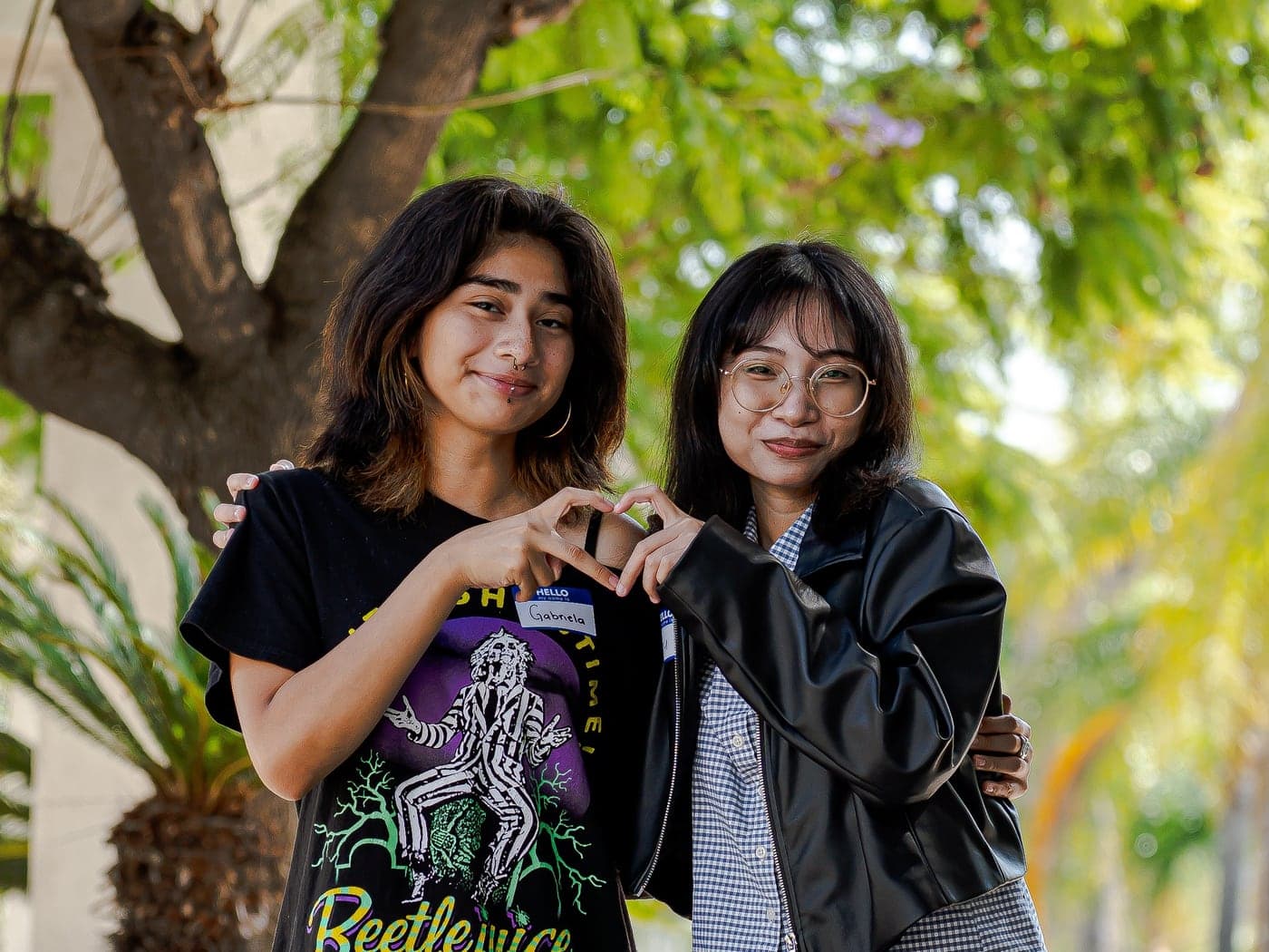 Two Youth Advisory Board members making a heart with their hands