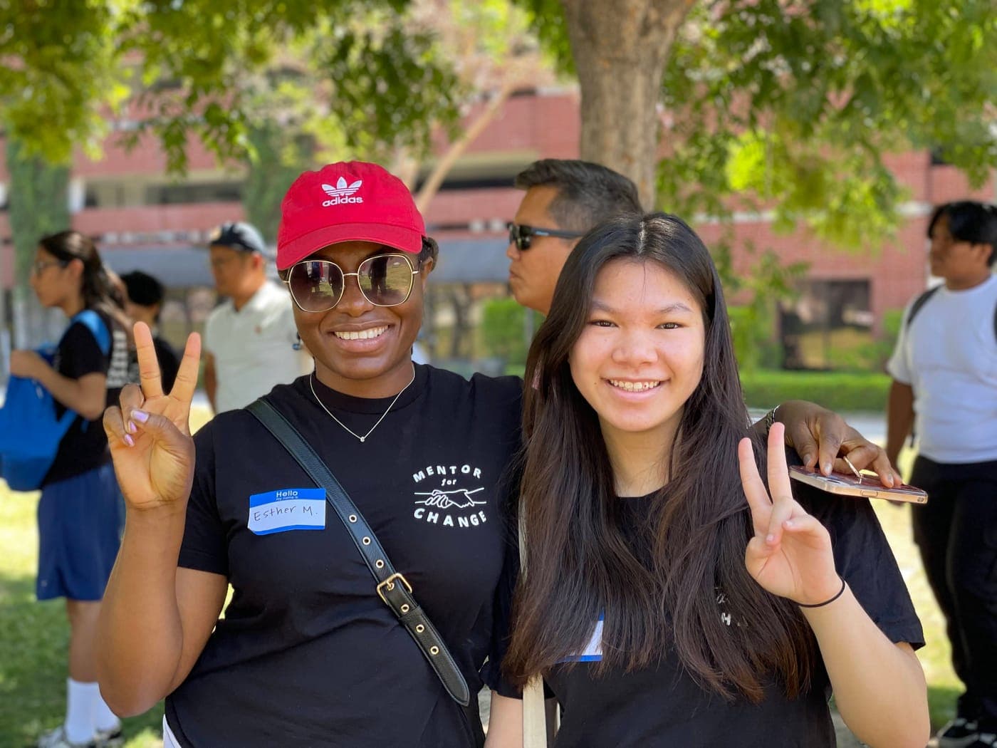 A mentor and mentee smiling and flashing peace signs