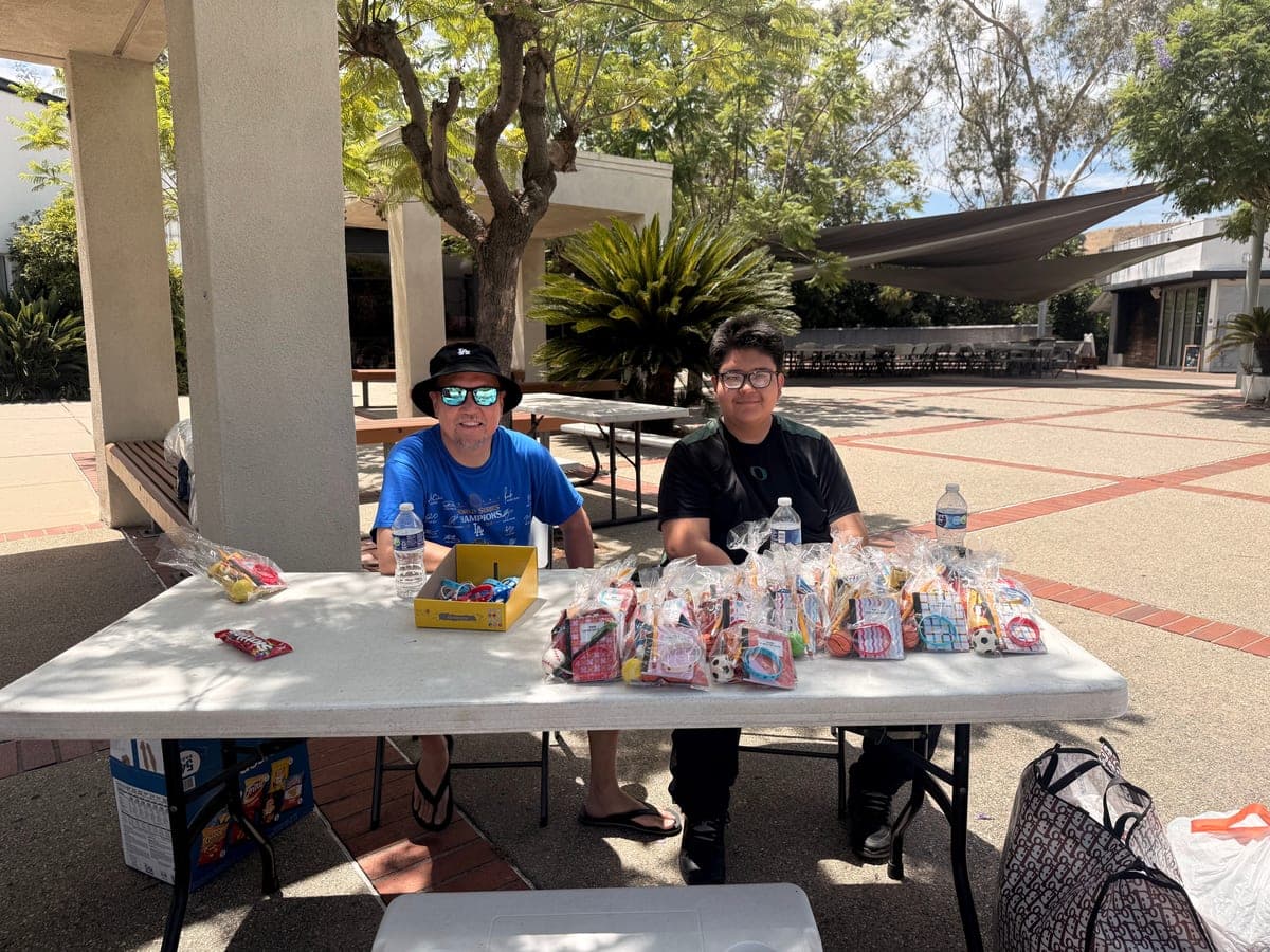 Youth volunteers at a community table with bags of treats